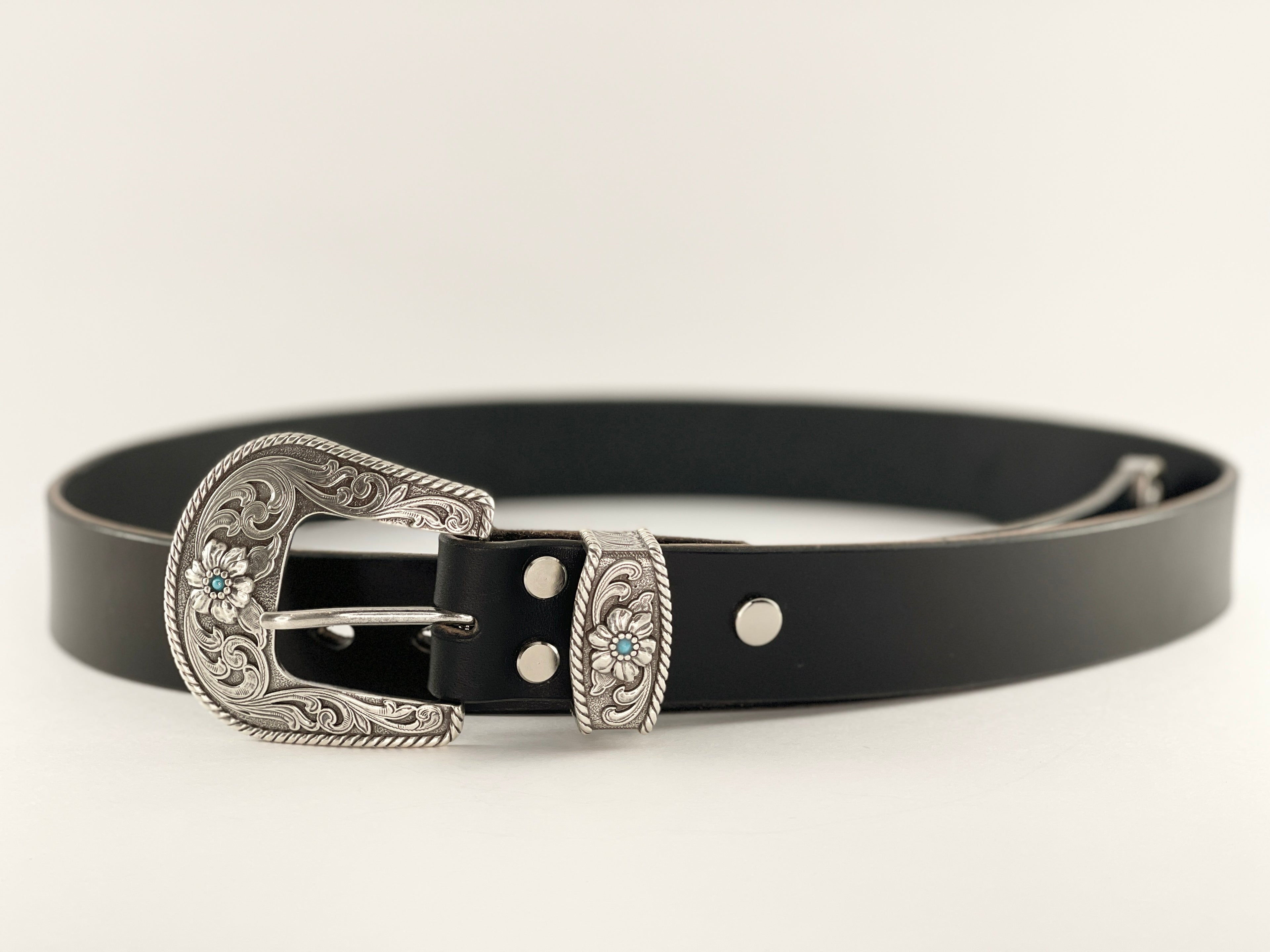 Black leather belt with silver buckle on a white background