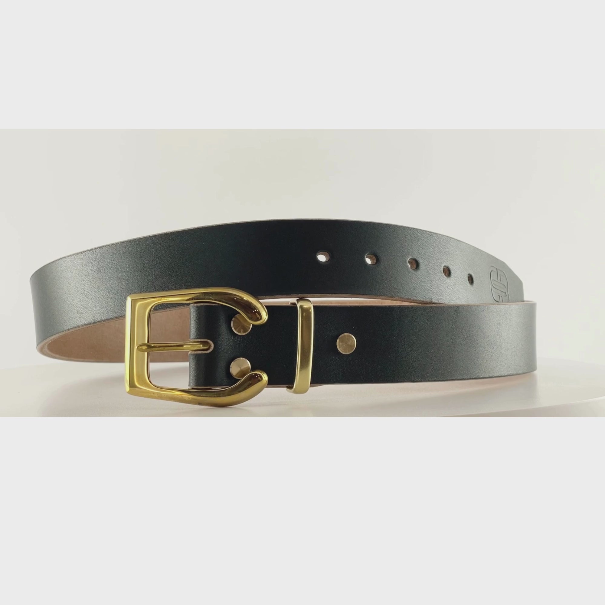 Video of a dark green belt with a horseshoe shaped shiny brass buckle on a carousel