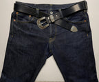Dark blue jeans with a black belt and silver buckle on a light gray background