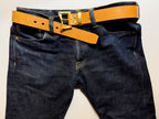 Blue jeans with brown leather belt and brass buckle with jeweled brass belt keeper