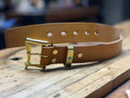 Brown leather belt with gold buckle on a wooden surface
