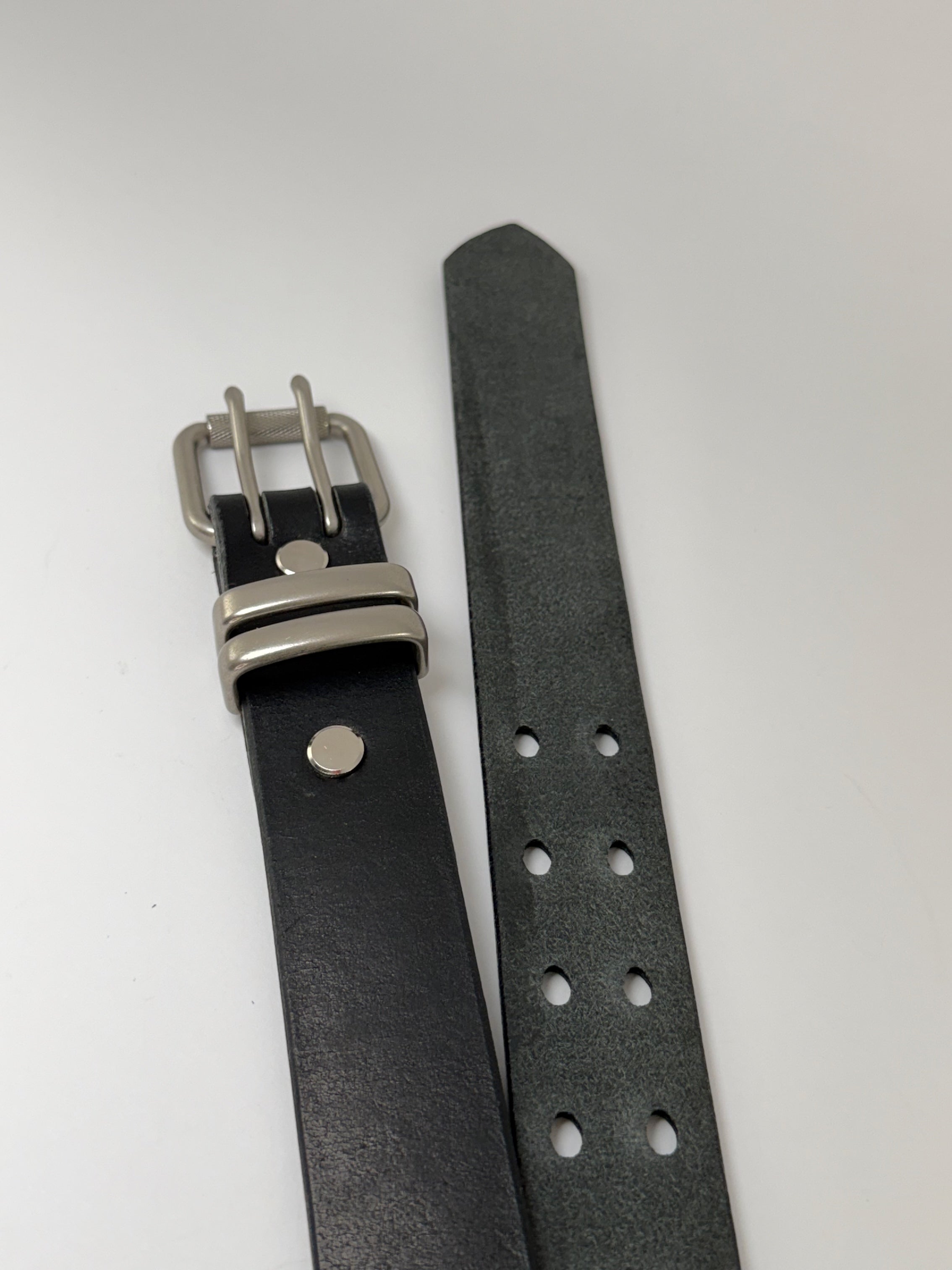 Black leather watch strap with silver buckle on a white background