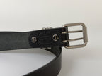 Back view of a black leather belt with silver buckle on a white background