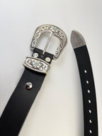 Black western cowboy belt with silver buckle and keeper adorned with turquoise stones on a white background