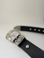 Black western cowboy belt with silver buckle and turquoise stones on a light gray background