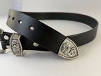 Black western cowboy belt with silver buckle and keeper adorned with turquoise stones on a white background