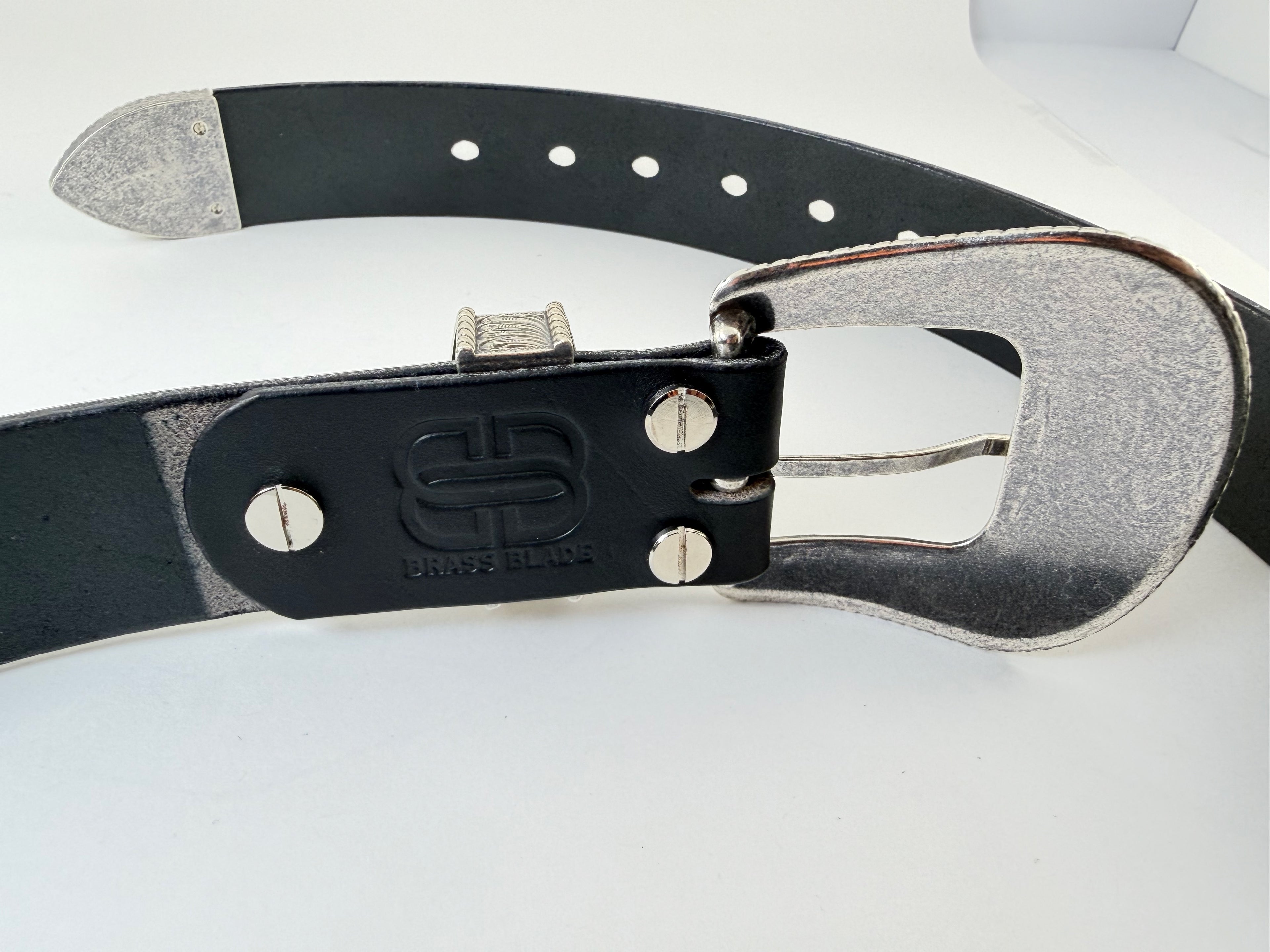 Back view of a black western cowboy belt with silver buckle and keeper on a white background