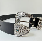 Close up of a black leather western cowboy belt with silver buckle and keeper adorned with turquoise stones on a white background