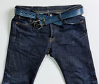 Blue jeans with a blue indigo leather belt on a white background