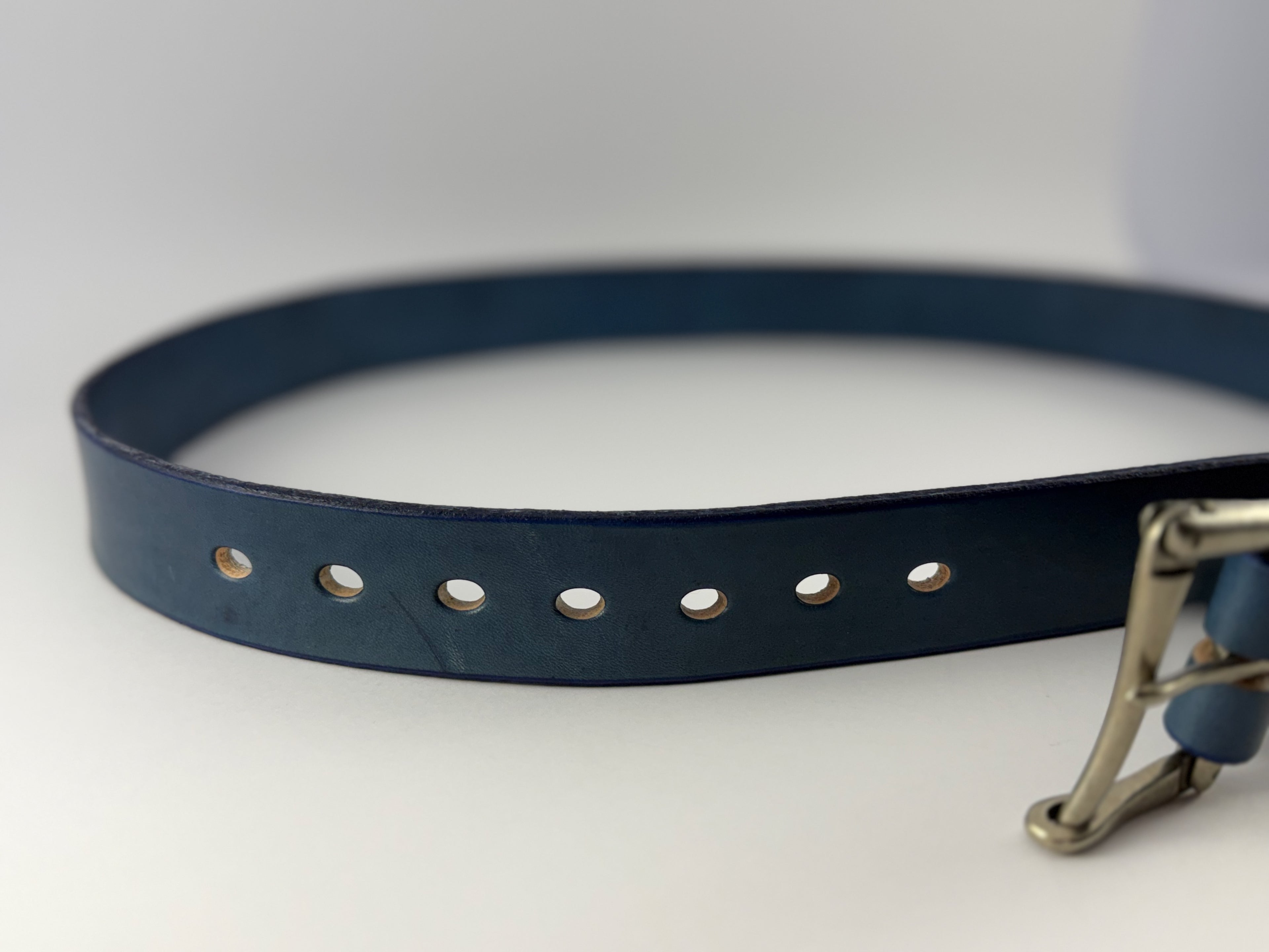 Blue leather belt with sliver buckle on a white background