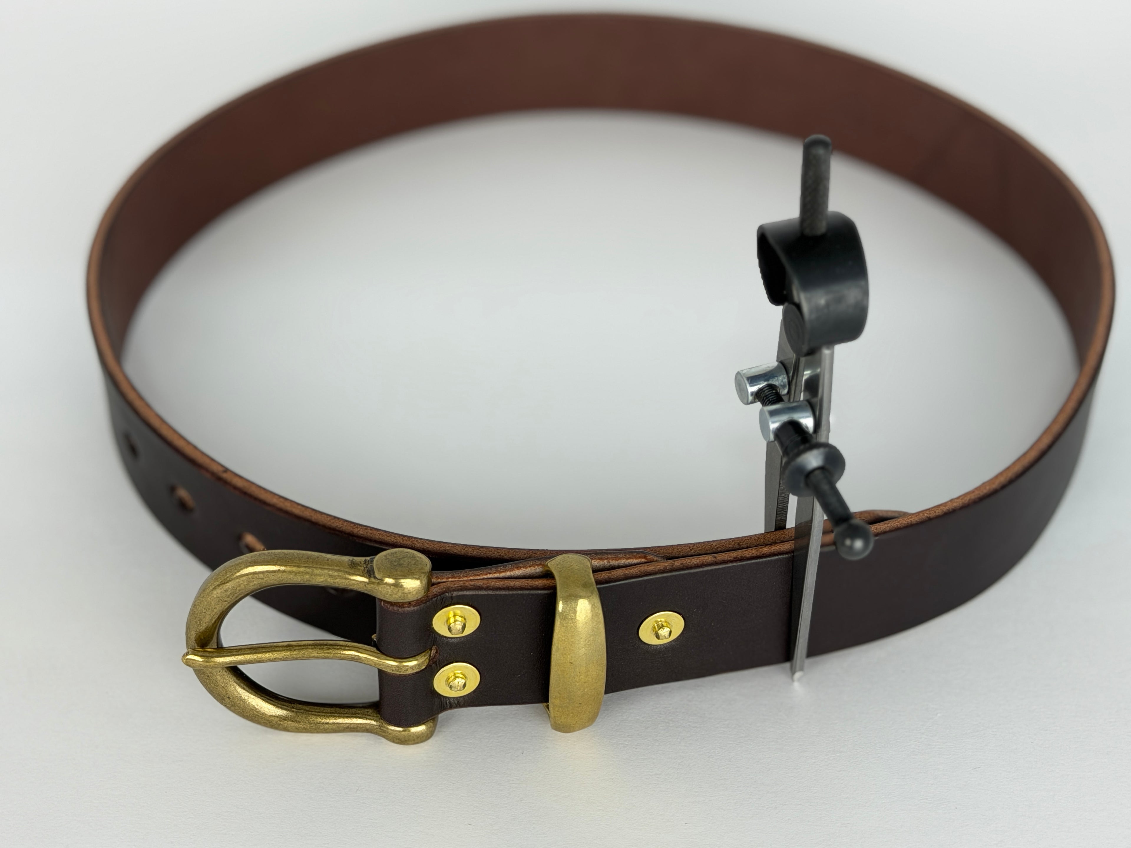 Top view of a brown leather belt with a close up of brass buckle, keeper and rivets.