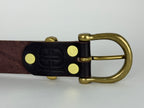 Picture of the back of a brown leather belt showing brass rivets and brass keeper and buckle.