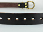 Close up picture of a leather belt showing oval-shaped belt holes.