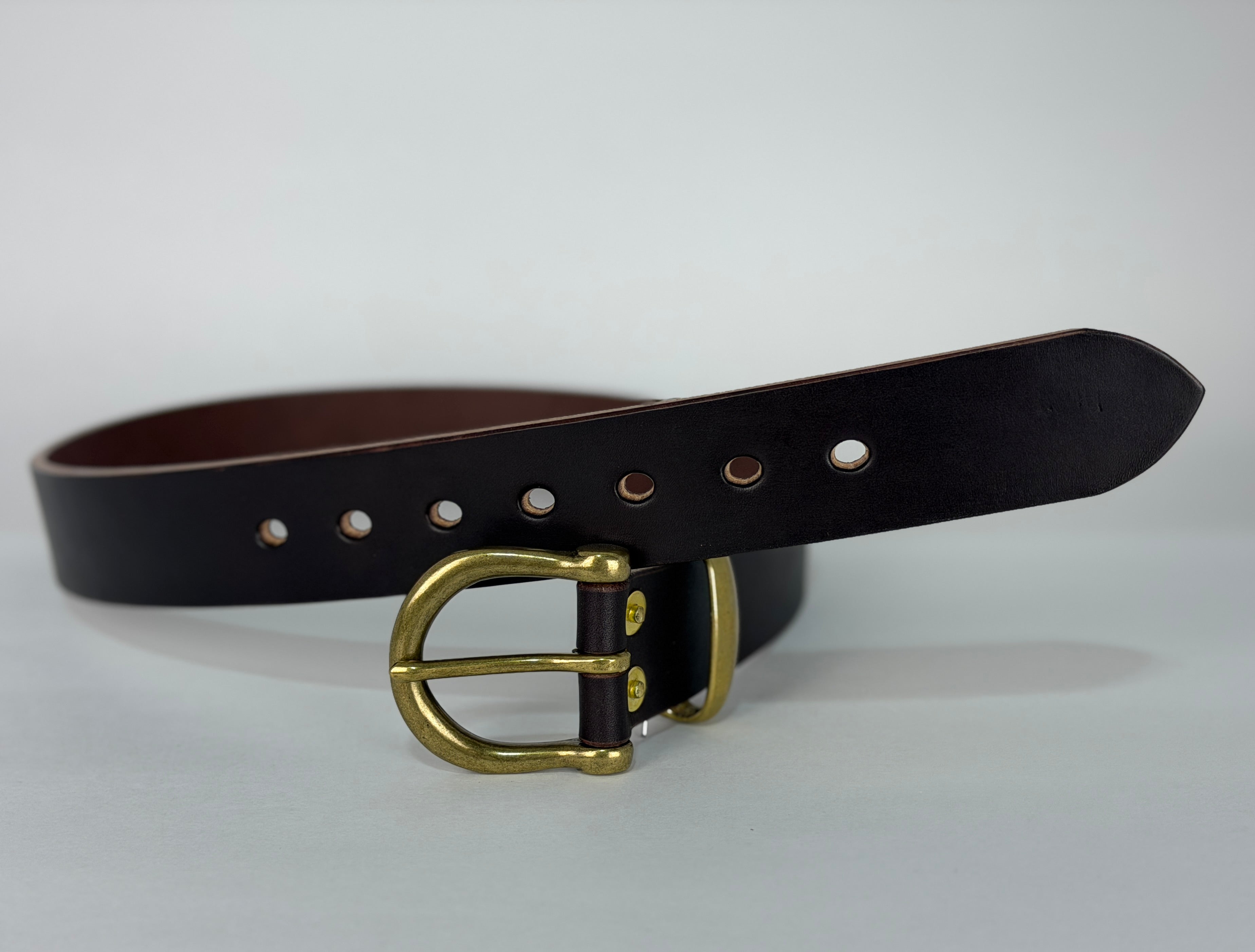 Picture of a brown leather belt on a white surface with a close up of brass buckle, keeper and rivets.