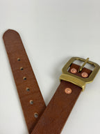 Brown leather belt with a brass buckle, keeper and copper rivets on a white background.