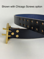 Navy leather belt with brass hardware on a white background.  The Chicago screws are being highlighted as an option and alternative to solid brass rivets.