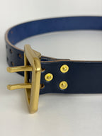 Navy leather belt with a brass buckle on a white background.  The brass rivets are being highlighted.