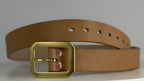 A frontal close up of a natural leather belt with a square brass buckle, displayed on a light gray background.