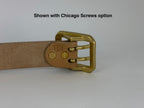 A close-up of a natural leather belt with a large rectangular brass buckle, showing the buckle hardware and two Chicago screws, with the text 'Shown with Chicago Screws option' at the top on a light gray background.