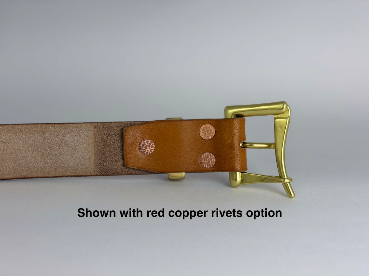 A close-up of the back of a tan leather belt with a brass buckle and copper rivets, shown against a light gray background with the text 'Shown with red copper rivets option' at the bottom.