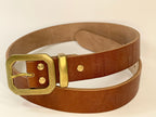 Brown leather belt with a gold buckle on a white background