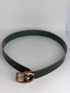 A dark forest green leather belt with a copper horseshoe  buckle, coiled on a light gray background.