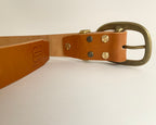 Brown leather belt with brass buckle on a white background