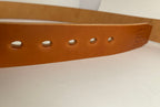 Brown leather belt with teardrop shaped holes on a white background
