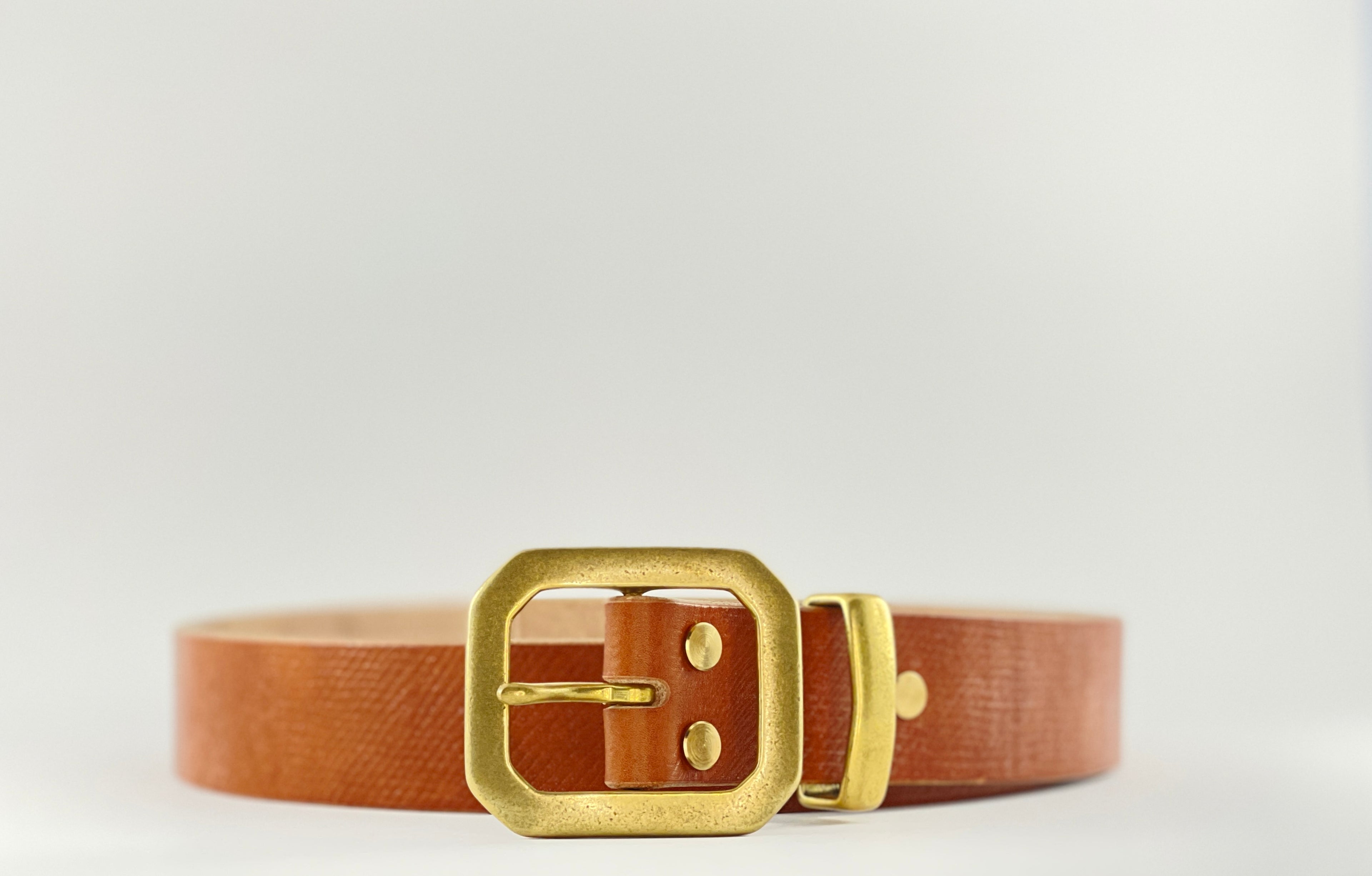 Brown belt with a gold buckle on a light gray background