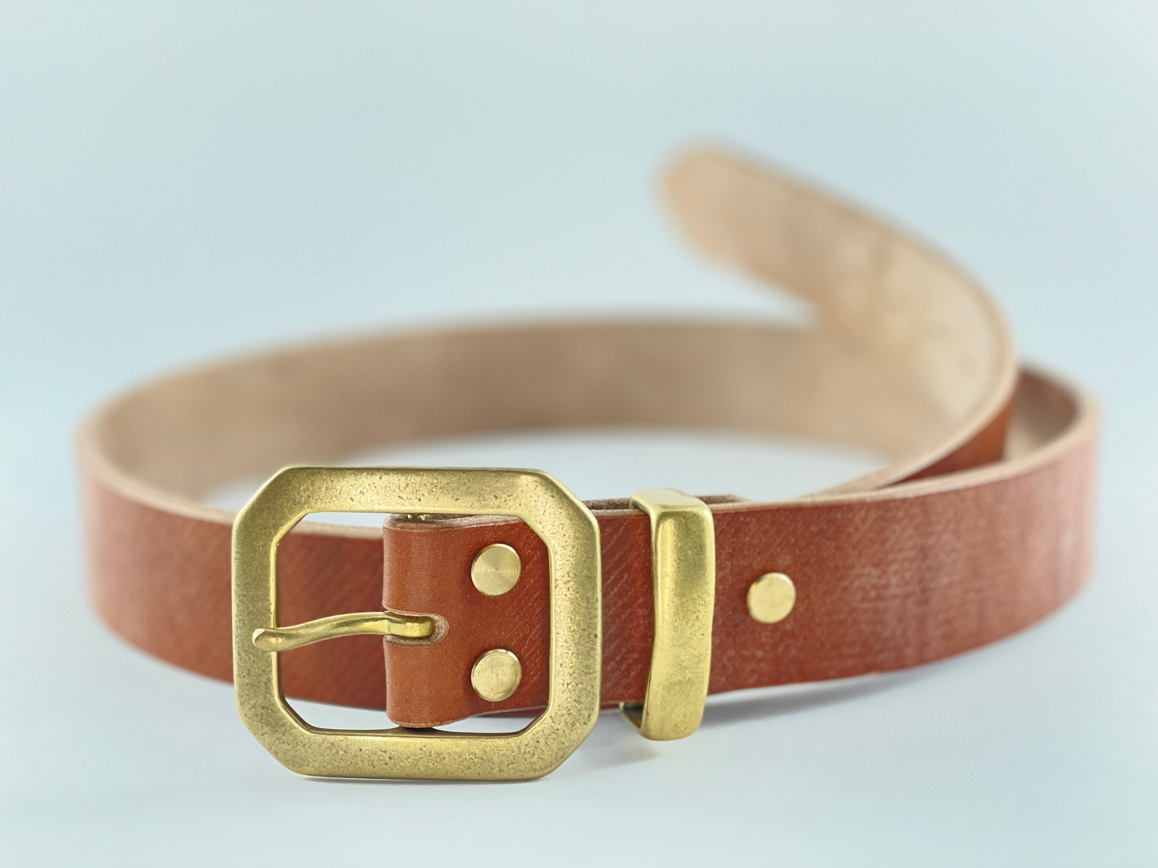 Brown belt with a gold buckle on a light gray background