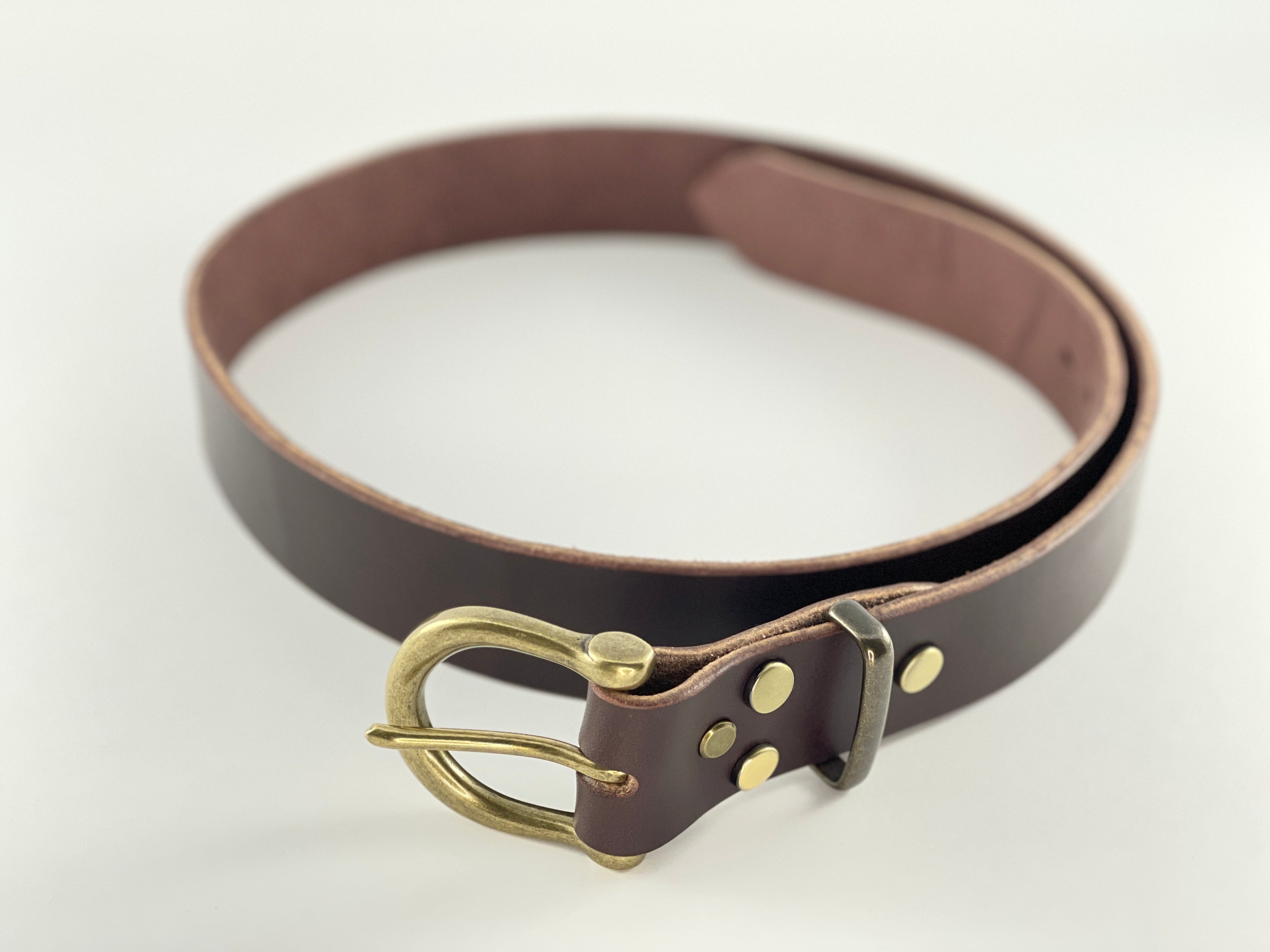 Brown leather belt with brass buckle on a white background