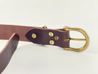 Brown leather belt with brass buckle on a white background