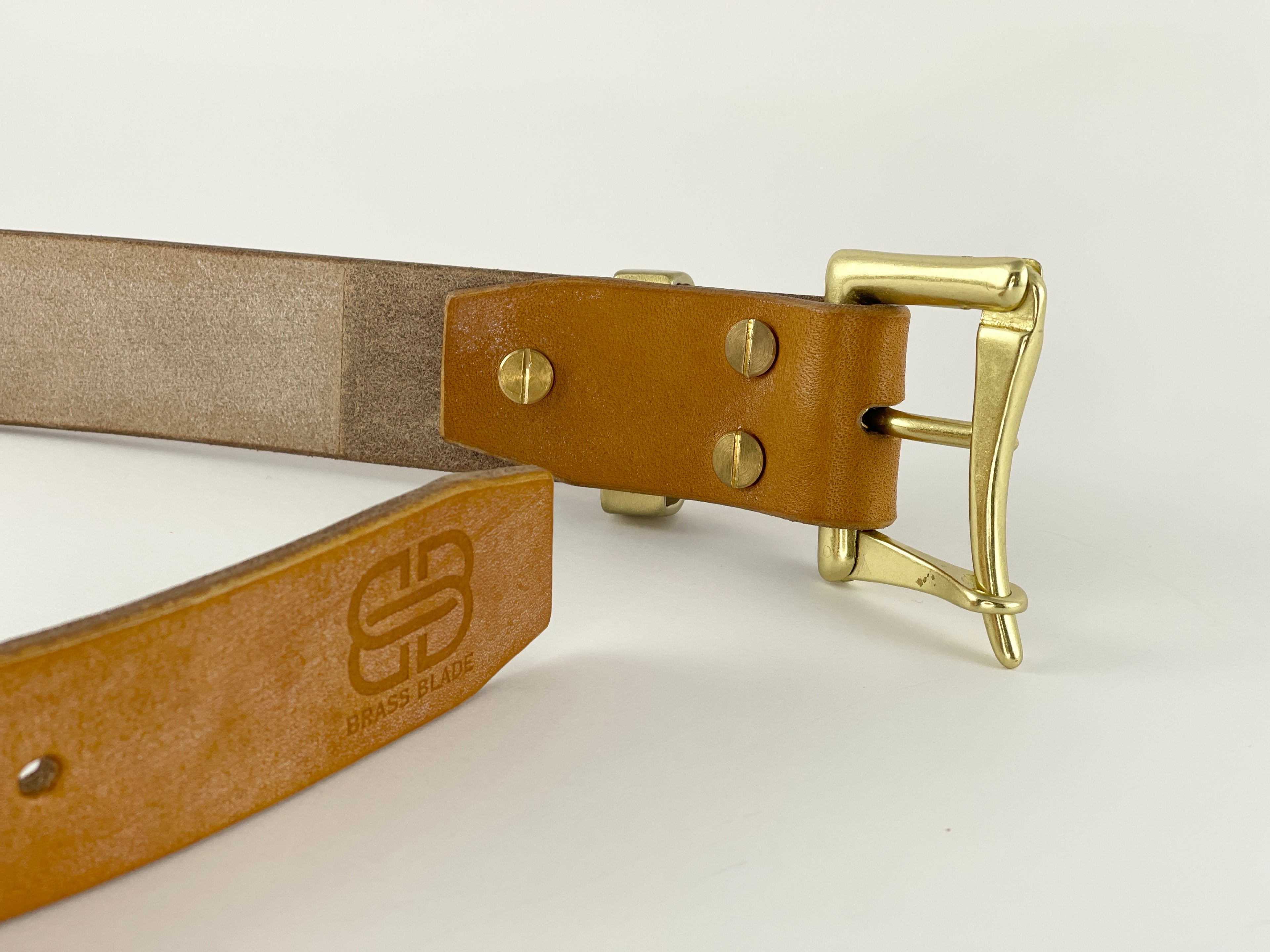 Brown leather belt with gold buckle on a light gray background