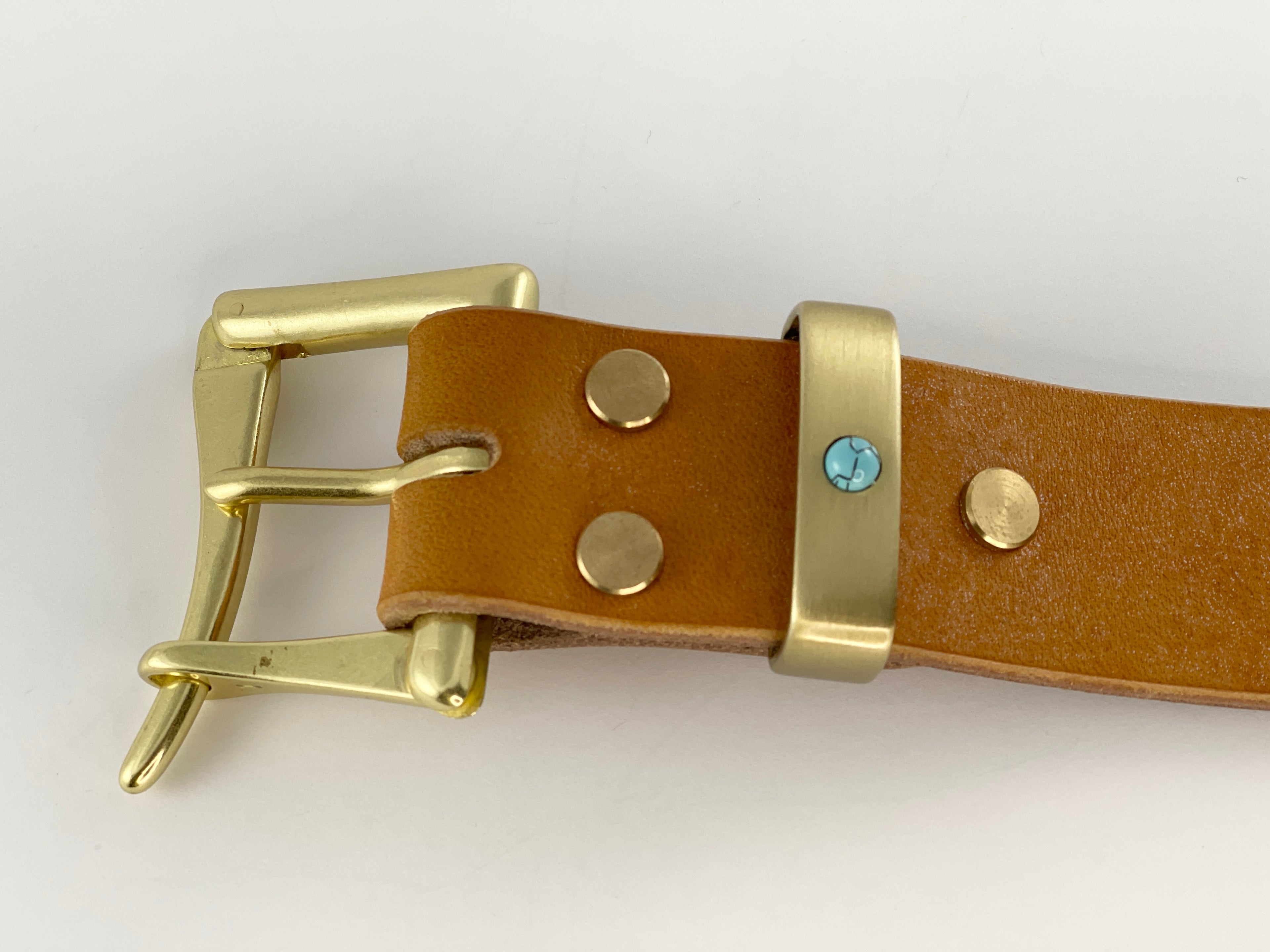 Brown leather belt with gold buckle and decorative studs on a white background