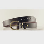 Video of a dark brown belt with a semi-circular brass buckle on a carousel
