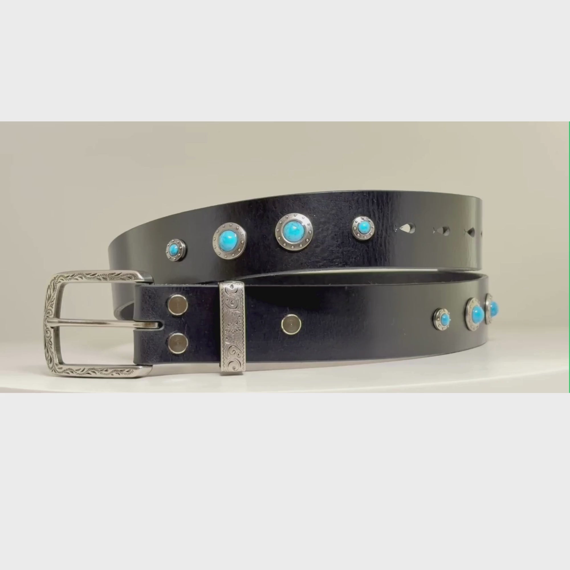 Video of a black belt with silver buckle and studded with turquoise conchos on a carousel