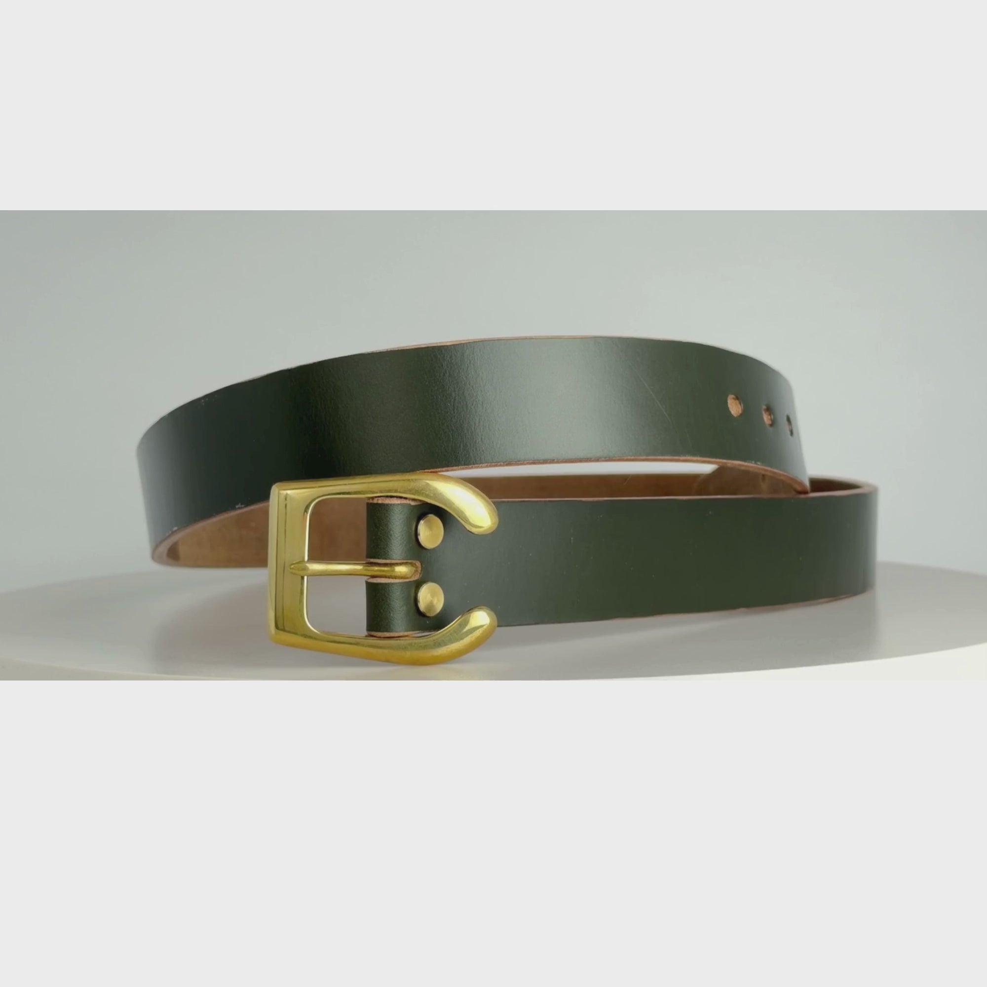 This is a video of a belt rotating on a carousel.  This belt is made from dark green leather, with a brass horseshoe buckle and brass Chicago screws.