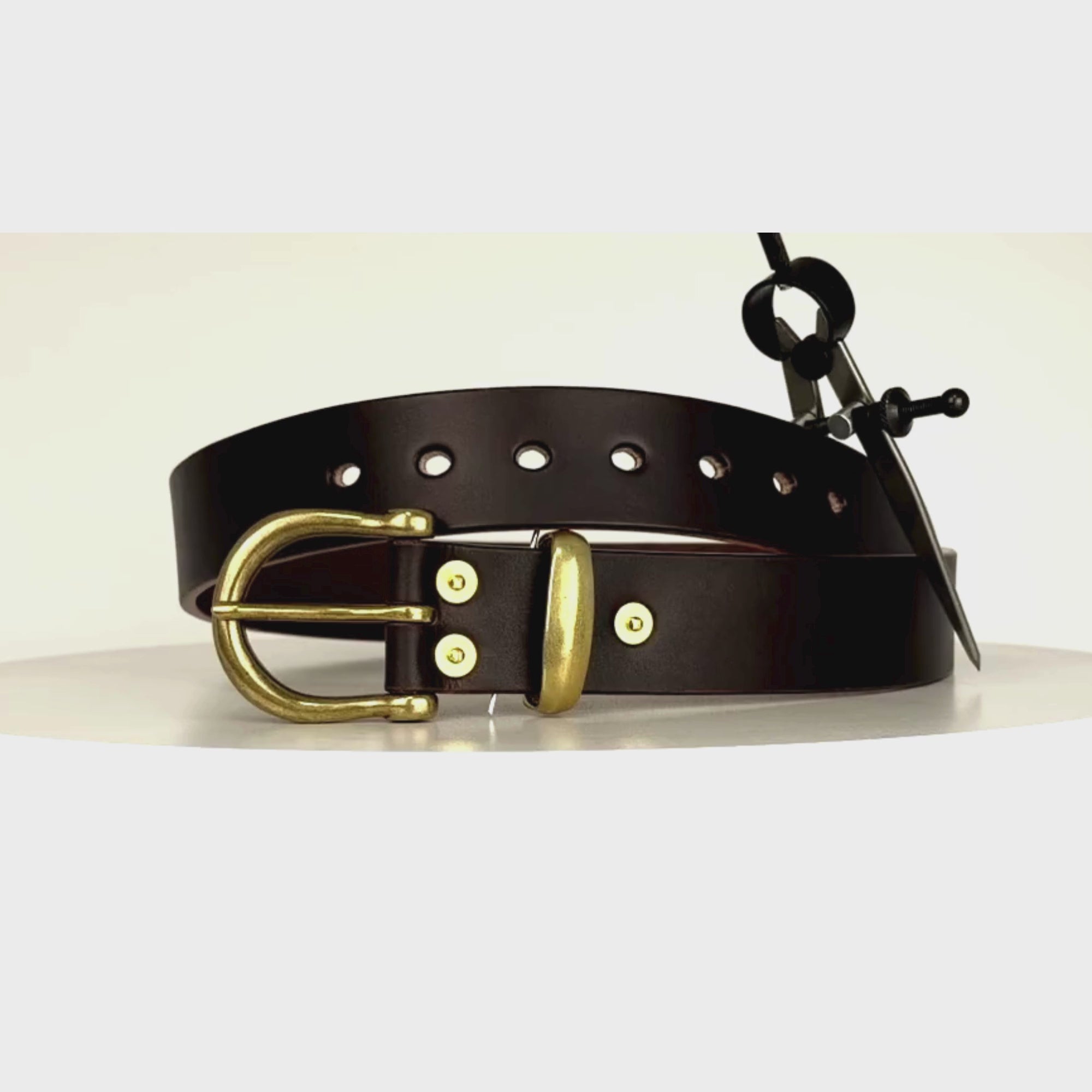 Video of a brown leather belt with brass buckle and keeper revolving on a carousel showing a 360 degree view of the belt