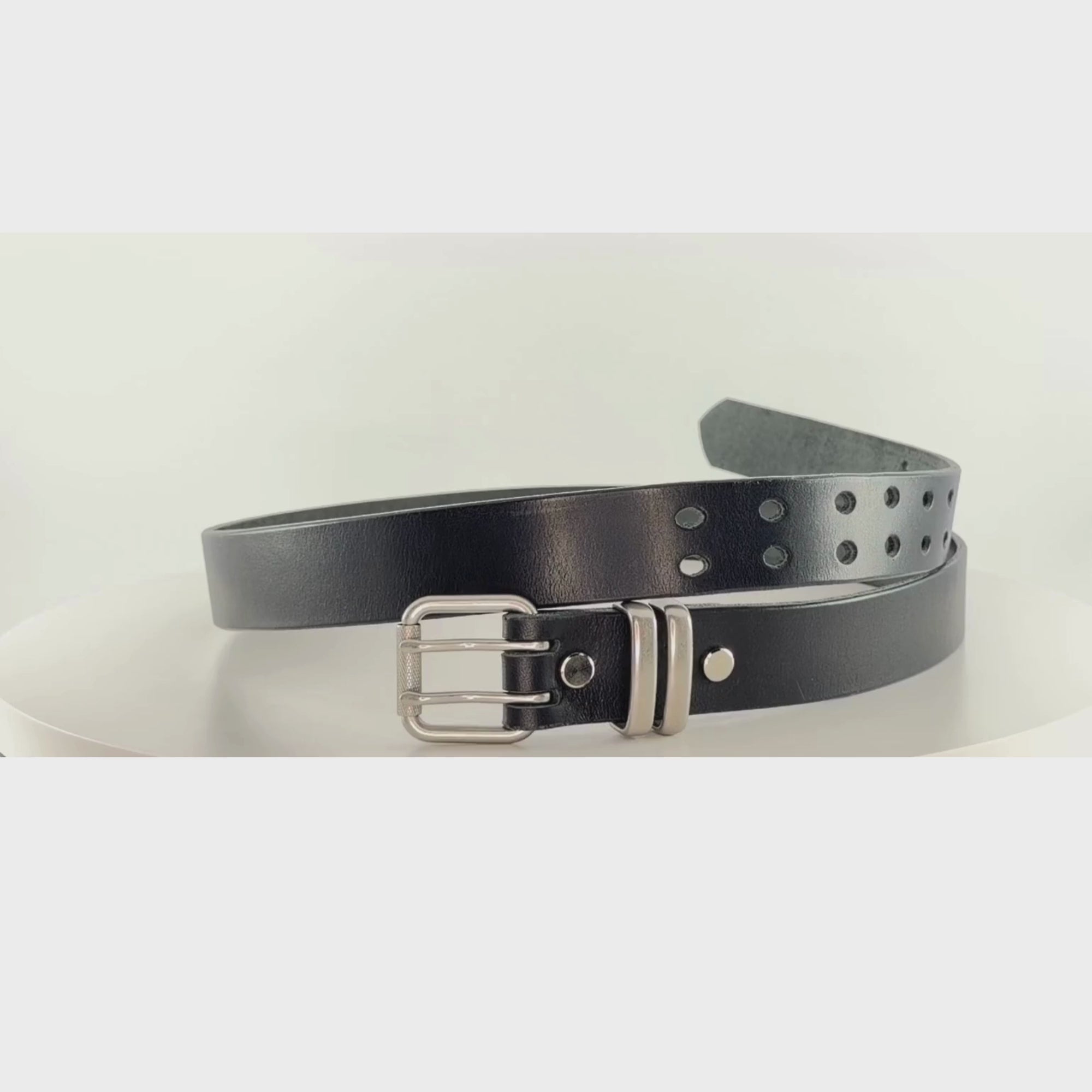 Video of a black leather belt with silver buckle and silver keepers rotating 360 degrees on a white carousel.
