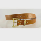 Video of a brown leather belt rotating on a carousel.  The belt has a brass buckle and belt keeper